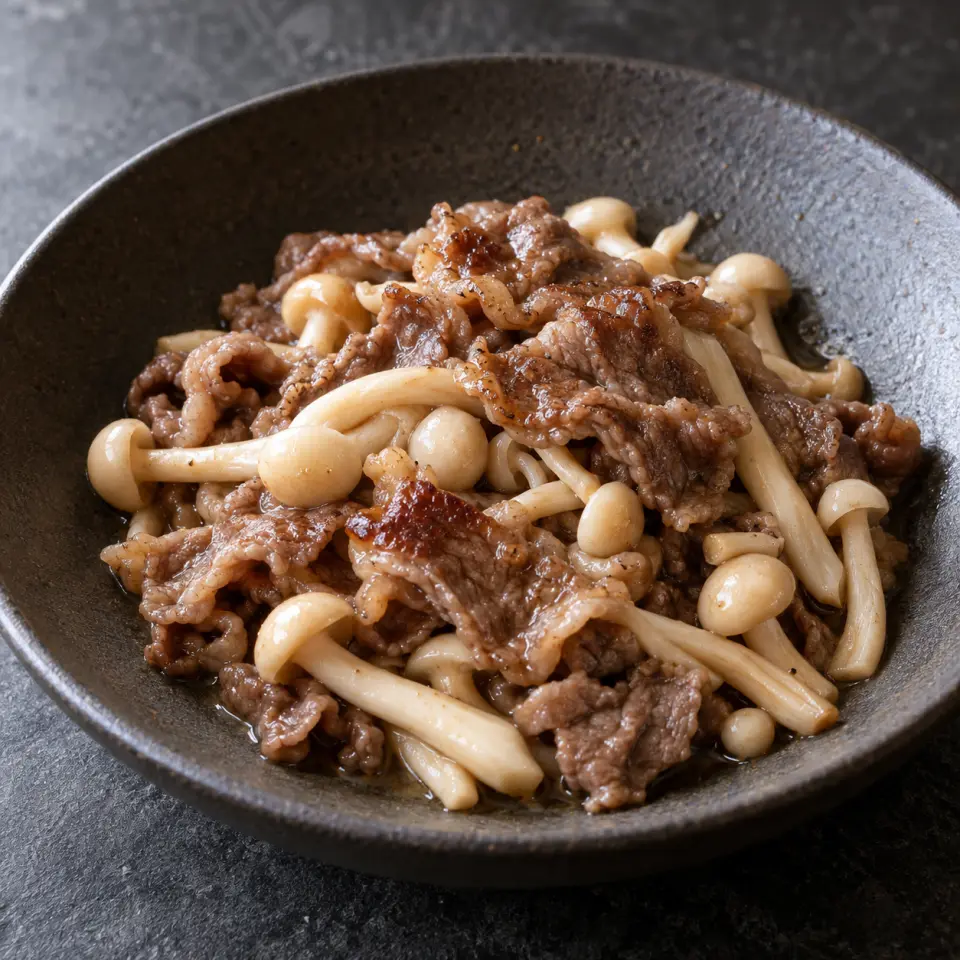 Beef Mushroom with Broccoli on a plate on a dark stone table, made with beef sukiyaki meat, white beech mushrooms, lemon juice.