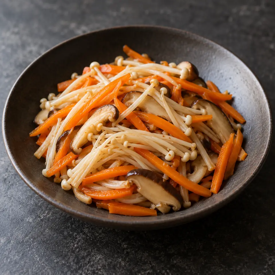 Enoki Carrots on a plate on a dark stone table, made with carrots, mushrooms, enoki.