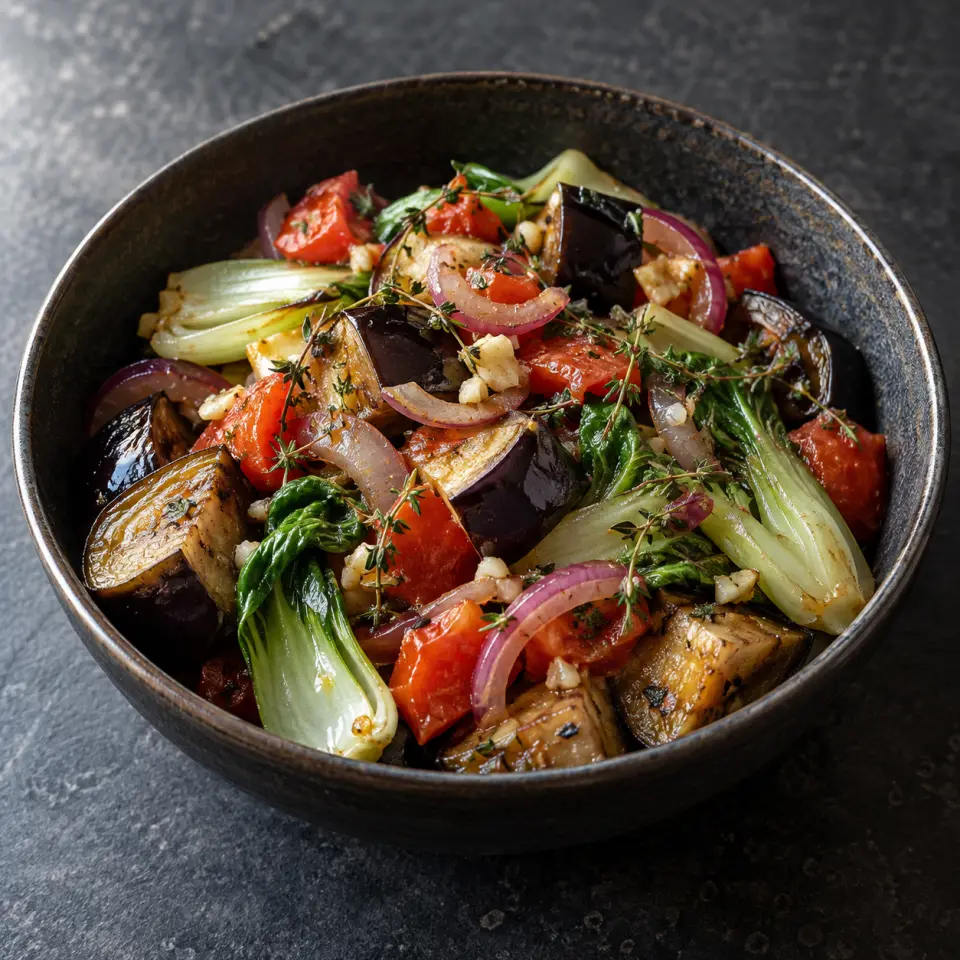 Tuna Tomato Bowl in a bowl on a dark stone table, made with eggplant, bok choi, tomatoes, lemon juice.